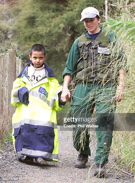 Five year old Siddharth Doshi walks out of the bush with paramedic Charmaine Tate wrapped in a police rescue jacket after he and six year old girl...