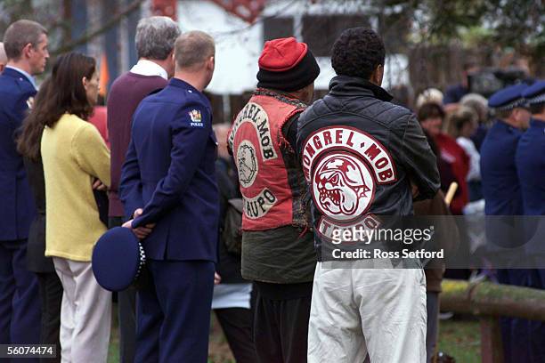 Police officers stand next to mongrel mob members outside the school where the funeral of murdered officer Murray Stretch was held today.