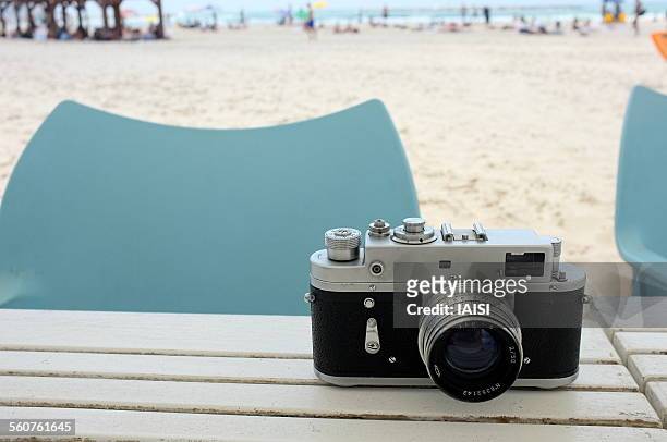 old film camera at the beach - camera point of view stock-fotos und bilder