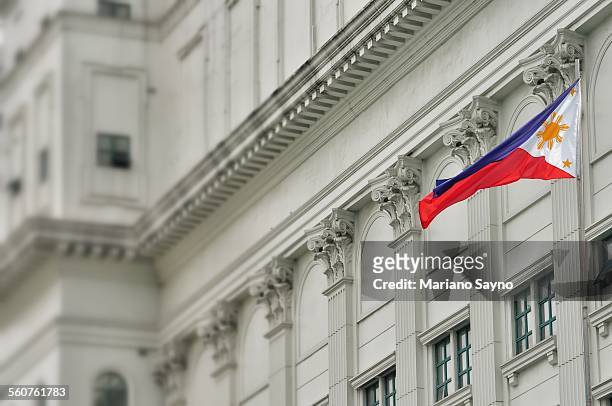 low angle view of philippine flag outside city bui - philippines flag stock pictures, royalty-free photos & images