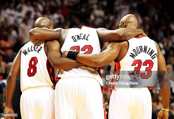 Shaquille O'Neal of the Miami Heat is helped off the court by teammates Antoine Walker and Alonzo Mourning after stepping on the foot of Ron Artest...