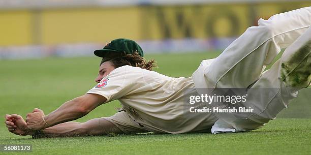 Nathan Bracken of Australia dives to catch Shivnarine Chanderpaul of the West Indies during day two of the First Test between Australia and the West...