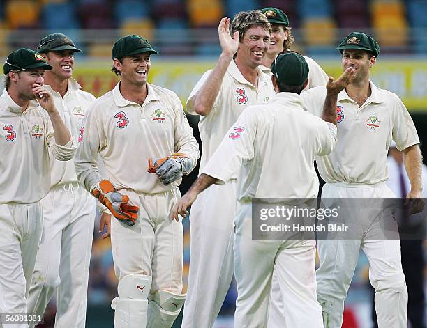 Glenn McGrath of Australia celebrates with team mates after taking the wicket Devon Smith of the West Indies during day two of the First Test between...