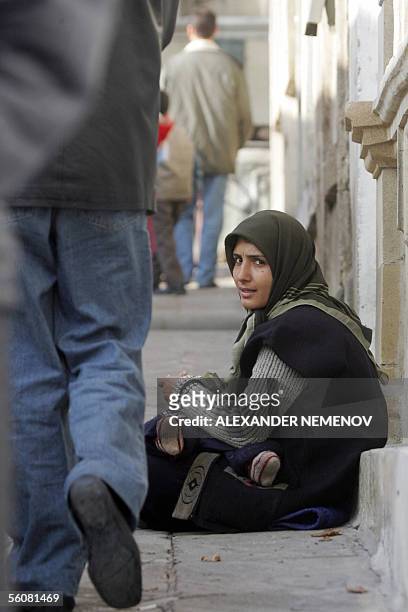 An Azeri Muslim woman begs outside the Taza Pir mosque in the center of Baku 04 November 2005 as Muslims celebrate the end of the Muslim month of...