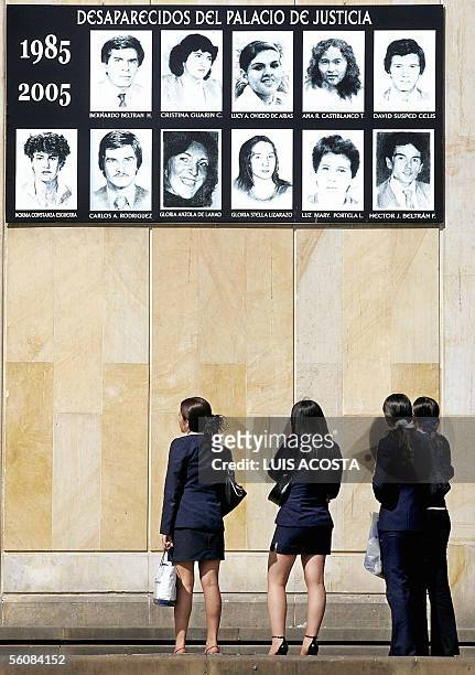 Un grupo de mujeres observa las fotografias de las personas desaparecidas en el Palacio de Justicia, en Bogota, el 4 de noviembre de 2005. Las fotos...