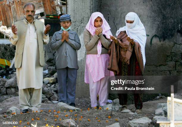 Pakistani family says a prayer over the grave for their family members kiled by the earthquake on Eid-Ul-Fitr November 4, 2005 in Muzaffarbad,...