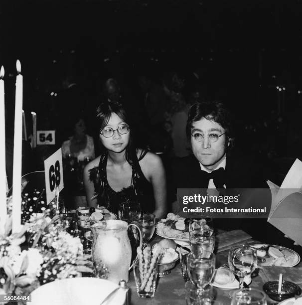 British singer-songwriter-musician John Lennon and his girlfriend American May Pang sit at their table during the gala dinner for the American Film...