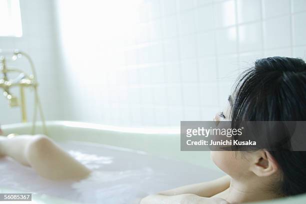 a young woman in bathtub - japanese women bath stock pictures, royalty-free photos & images