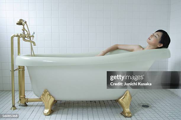 a young woman in bathtub, side view - japanese women bath stock pictures, royalty-free photos & images