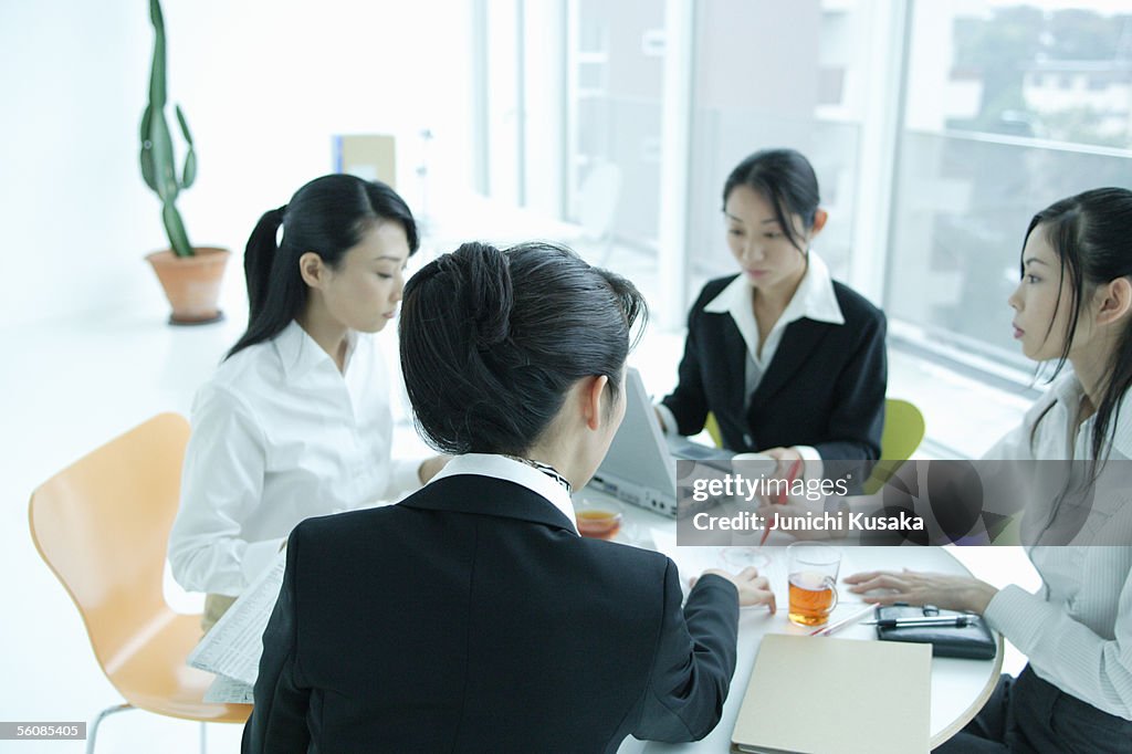 Small group of young women having meeting in office, close-up