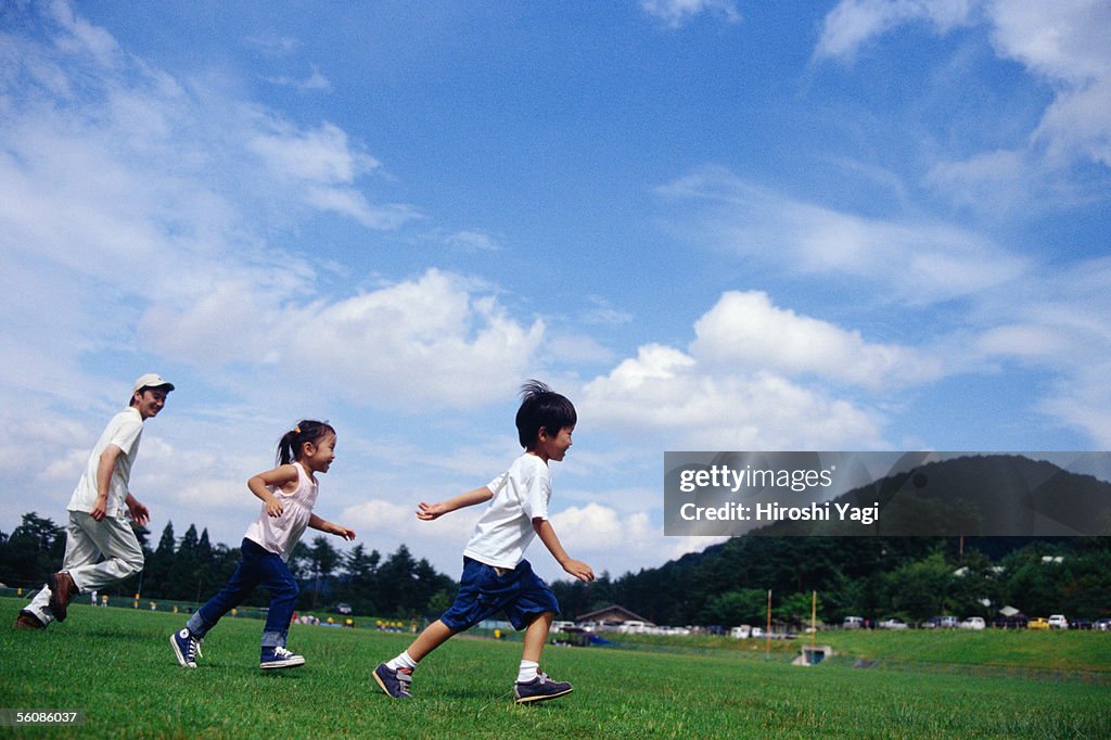 A boy and a girl running in a park