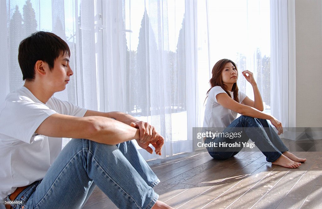 A young couple sitting on floor