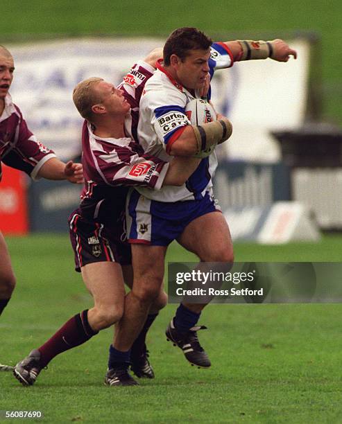 Auckland Warriors Terry Hermansson attempts to break the tackle of Northern Eagles Michael Buettner in the final NRL match at Ericsson Stadium,...