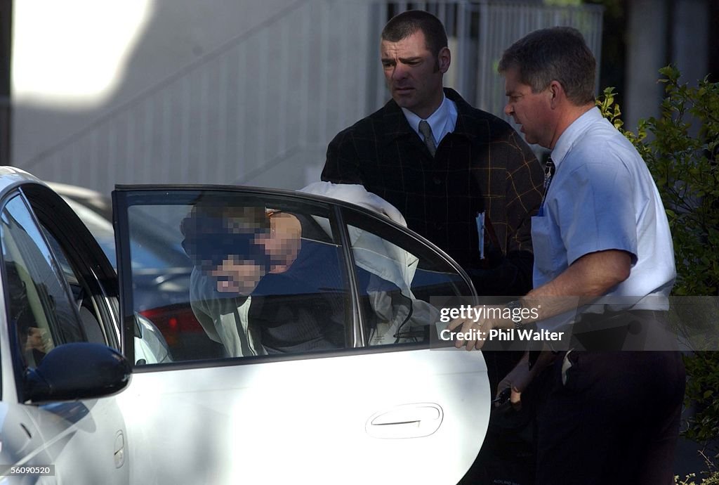 A handcuffed suspect is put into a police vehicle