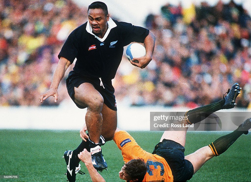 All Black Jonah Lomu slips the tackle of Australia