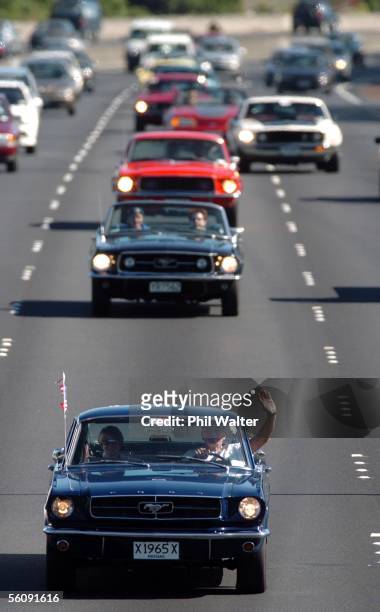 Denis Jones and Vickie Steel both from Takapuna, wave from their Ford Mustang as they lead a group of Mustangs on Auckland's Southern Motorway, New...