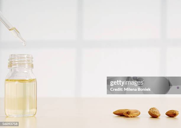 essential oil, dropper and almonds - almond oil stockfoto's en -beelden