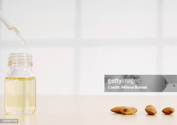 essential oil, dropper and almonds - almond oil stock pictures, royalty-free photos & images