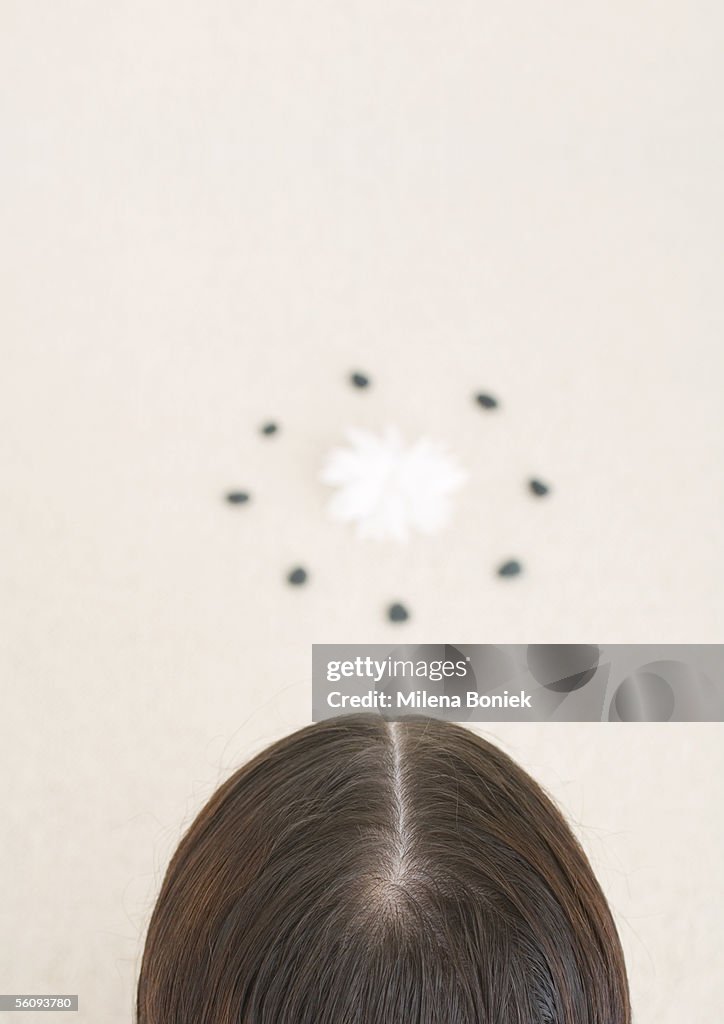 Back of woman's head and flower inside circle