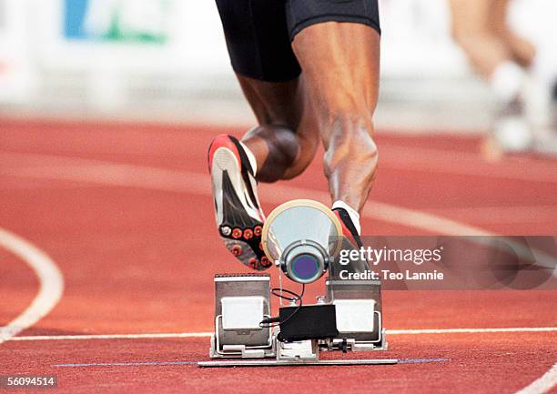 male runner leaving starting block, low section - mens track photos et images de collection