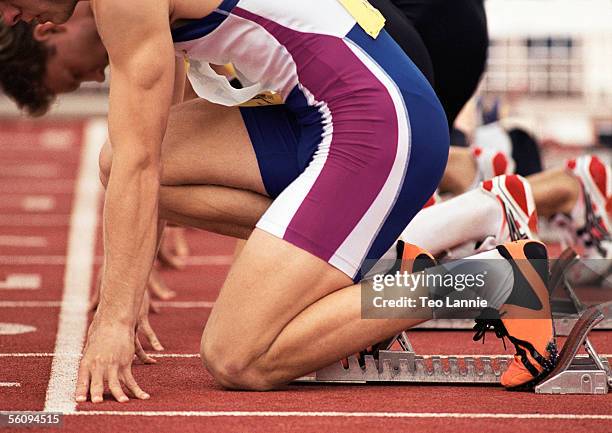 male runners on starting block, close-up - sports event stock pictures, royalty-free photos & images