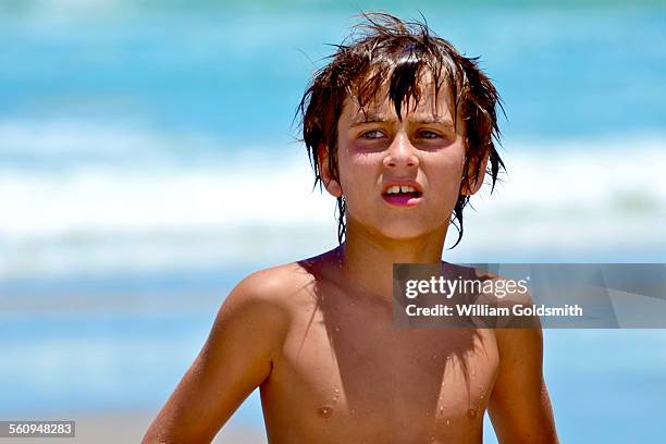 boy looking across beach with ocean in background - tülle stock-fotos und bilder