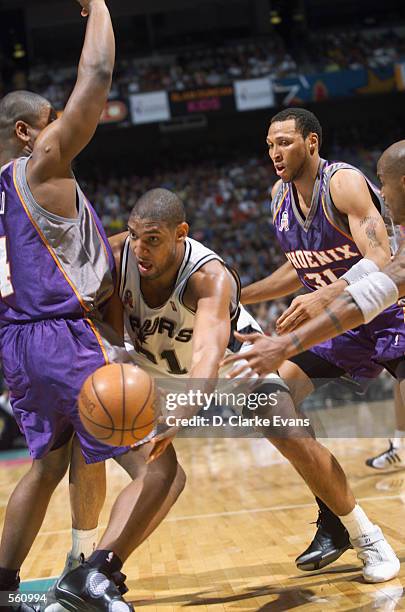 Center Tim Duncan of the San Antonio Spurs passes around forward Alton Ford of the Phoenix Suns during the NBA game at the Alamodome in San Antonio,...