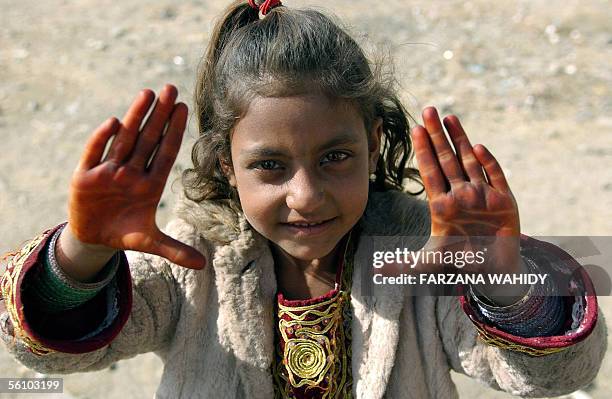 An Afghan child shows her hands covered with Henna in Kabul, 06 November 2005, after they were decorated for the Muslim Eid al-Fitr Festival. The...