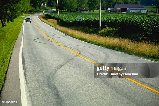 car approaches swerving tracks on a country road - swerve stock pictures, royalty-free photos & images