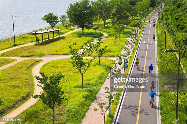 cycling on riverside park - korea city stock pictures, royalty-free photos & images