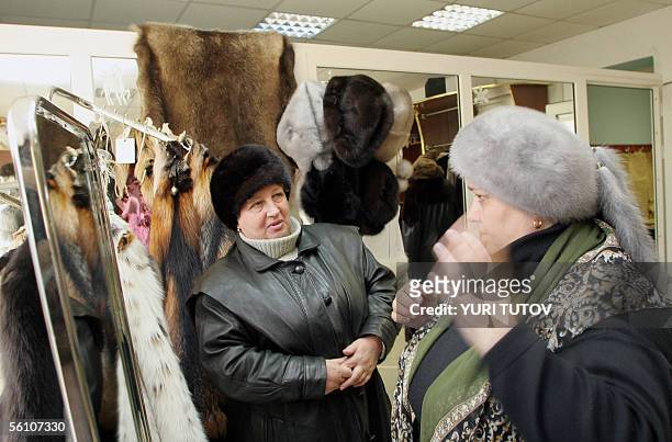 Picture taken 03 November 2005 shows woman trying fur hats at a farm in Pushkino, some 40 kms from Moscow. From Soviet leaders to high society icons,...