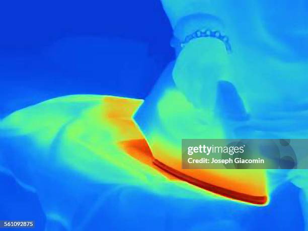 thermal image of womans hand ironing at home - wärmebild stock-fotos und bilder