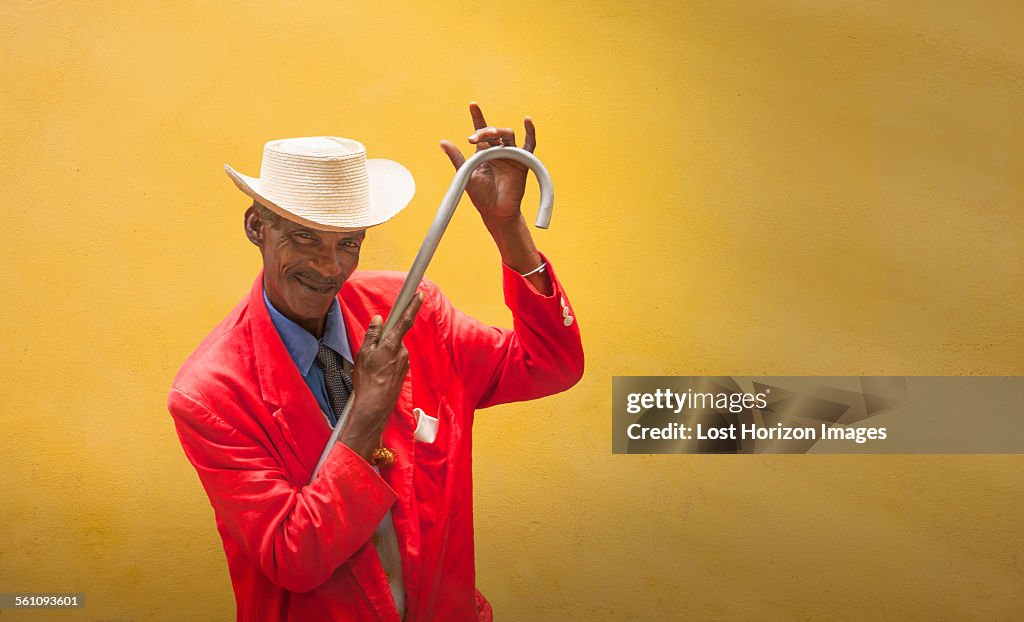 Mature male dancer poised in front of yellow wall, Havana, Cuba