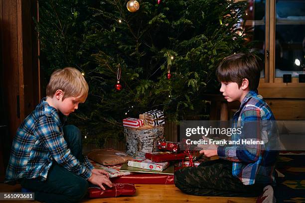 two brothers opening christmas presents - hemavan stock pictures, royalty-free photos & images