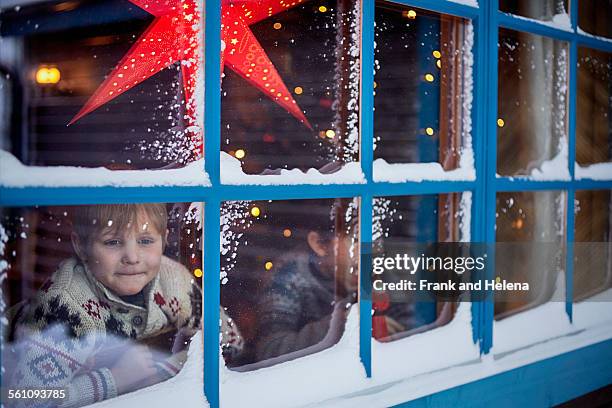 two brothers looking out of cabin window at christmas - hemavan stock pictures, royalty-free photos & images
