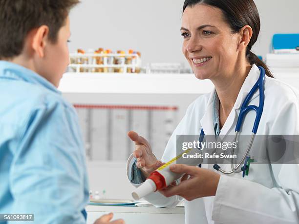 doctor explaining lung function test to young boy in clinic - spirometer stock pictures, royalty-free photos & images