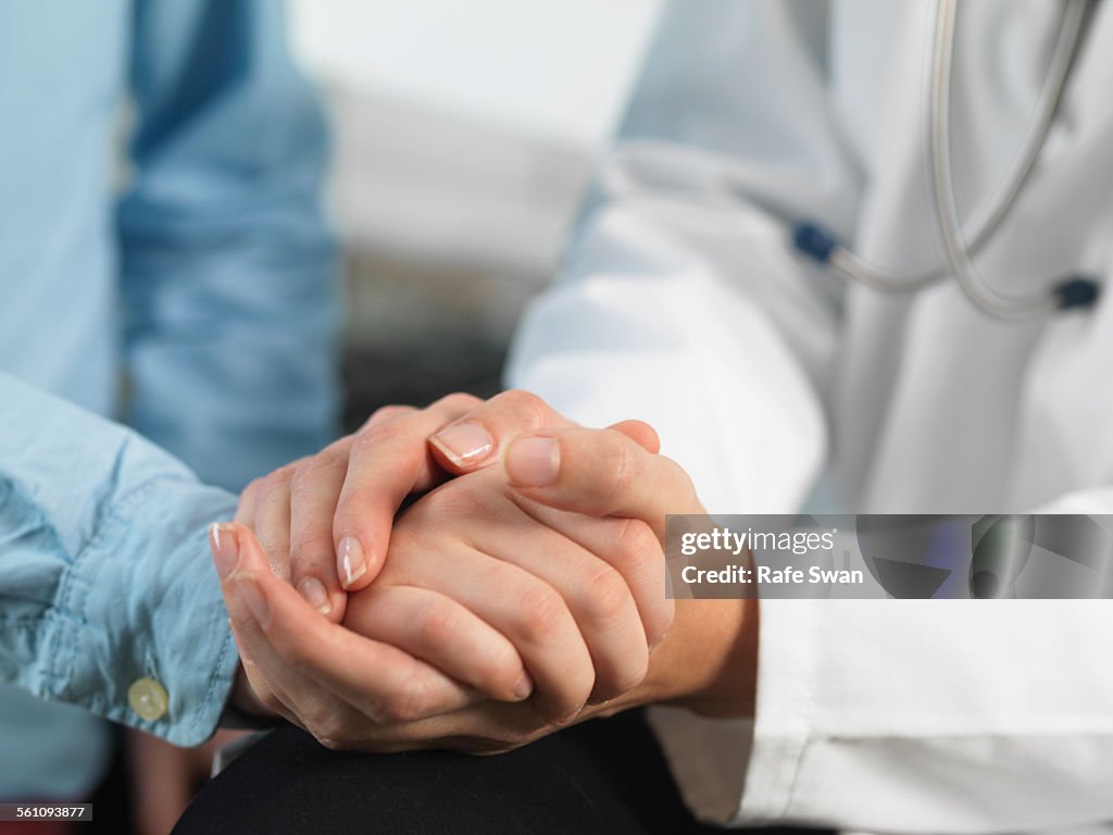 Doctor comforting young boy in clinic