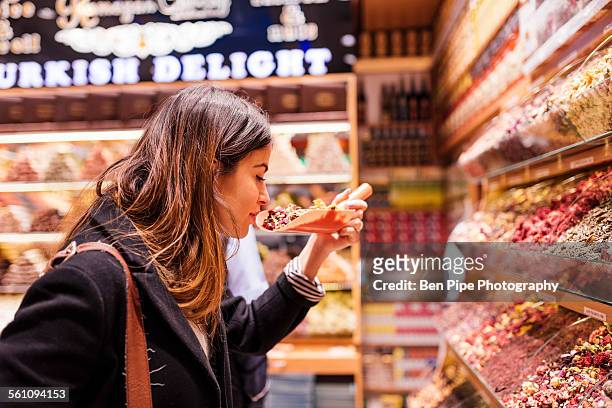 young woman smelling food in market, istanbul, turkey - smelling food imagens e fotografias de stock