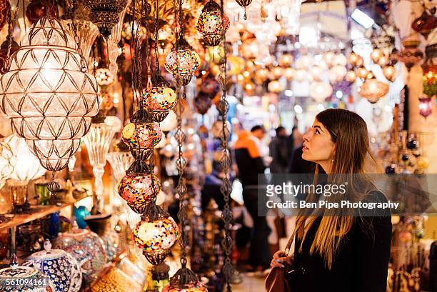 young woman looking at lights on market stall, istanbul, turkey - istanbul stock pictures, royalty-free photos & images