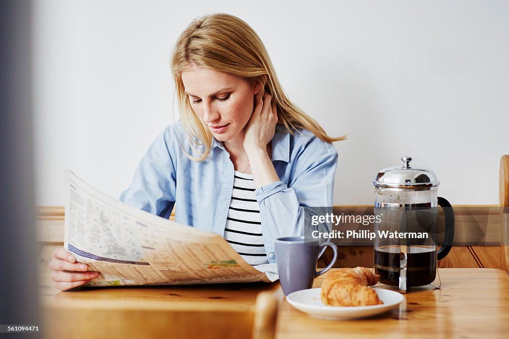 Mid adult woman reading newspaper