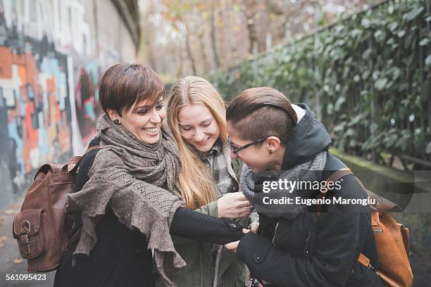 three sisters walking by graffiti wall - girl power graffitti stock pictures, royalty-free photos & images