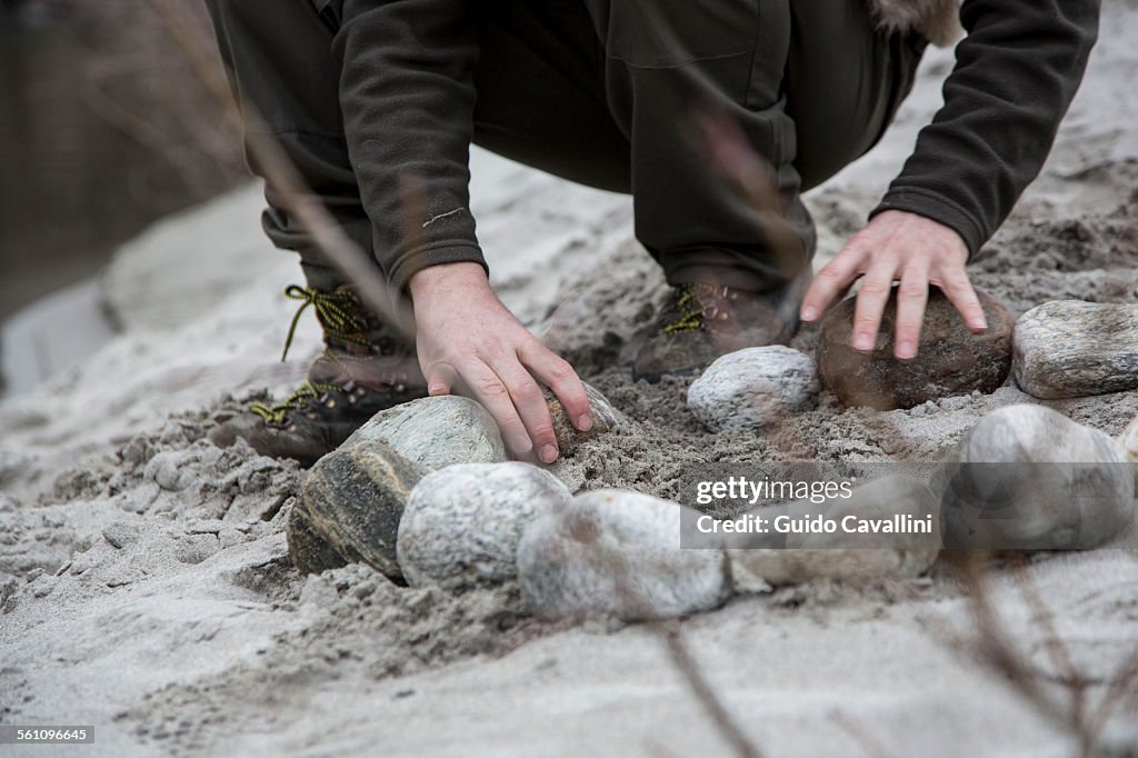 Man making campfire with rocks