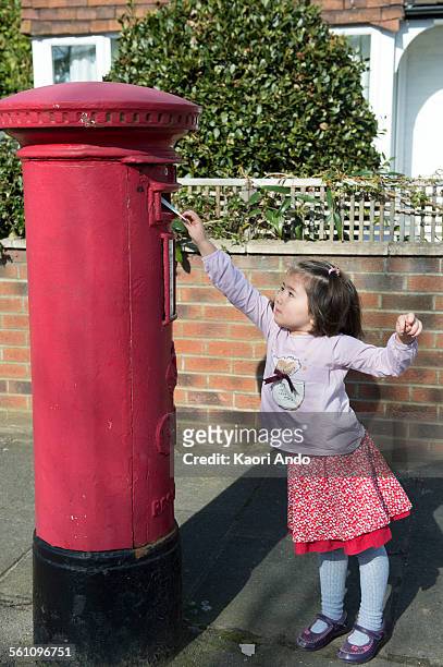 young girl at post box, reaching up to post letter - answering stock pictures, royalty-free photos & images
