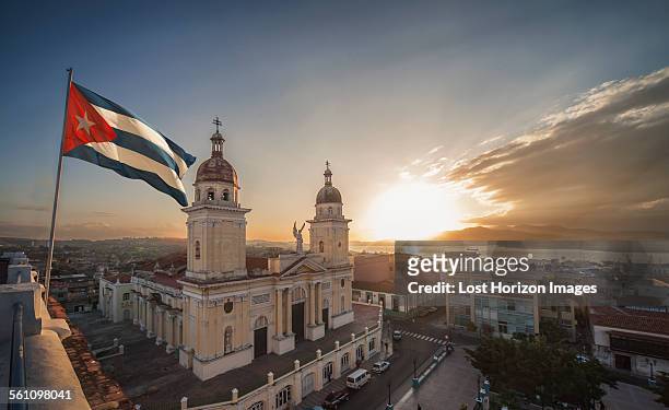 cuban flag over plaza de la cathedral at sunset, santiago de cuba, cuba - cuba culture stock pictures, royalty-free photos & images
