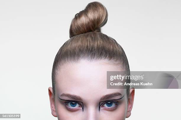 young woman with her hair in a tight bun, cropped. - chignon bun photos et images de collection