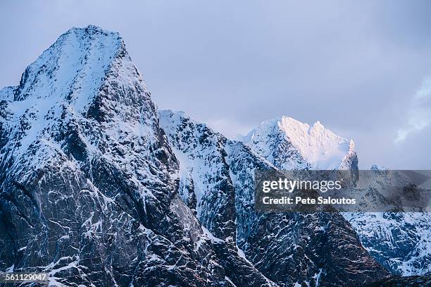 view of snow capped mountains and storm clouds, reine, lofoten, norway - moskenesoya stock pictures, royalty-free photos & images
