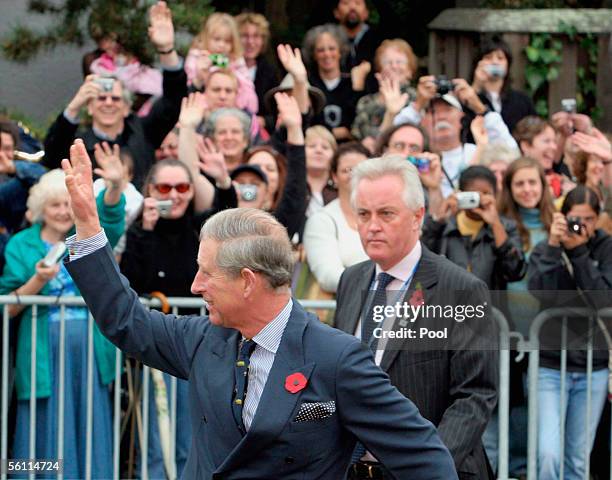 Prince Charles, Prince of Wales, waves to the crowd during the arrival with his wife Camilla, Duchess of Cornwall to Martin Luther King Middle School...