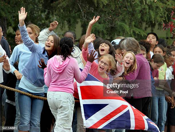 Students wave as Prince Charles, Prince of Wales, and his wife Camilla, Duchess of Cornwall, arrive at Martin Luther King Middle School November 7,...