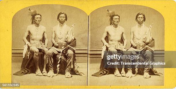 Photographic stereo view records two Native Americans unadorned in an unknown photo studio, and, circa 1860.