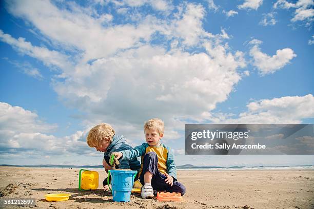 children playing on the beach together - family summer holiday stock pictures, royalty-free photos & images